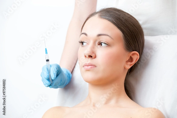 Obraz  woman  looks frightened at a syringe