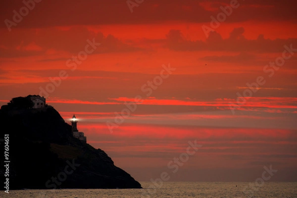 Obraz Beaming lighthouse in the red dusk 