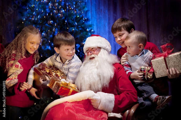 Fototapeta Santa giving Christmas Presents to Happy Children