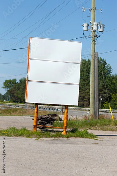 Fototapeta Empty billboard with electricity pylon at roadside
