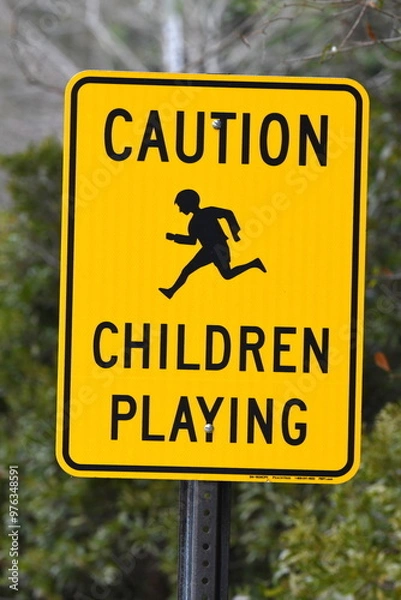Obraz A bright yellow and black sign that says Caution Children Playing and has a picture of a child running.