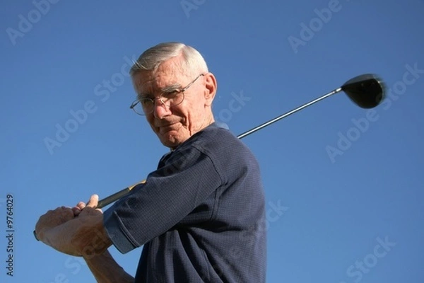 Fototapeta Senior golfer with club against blue sky
