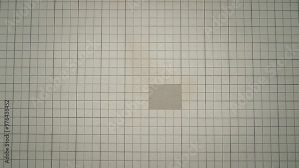 Obraz A photo of a clean background with a lot of negative space. The background is a light gray surface with a few small, dark gray squares scattered across it. The overall image has a minimalistic