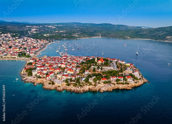 Fototapeta Primosten, Croatia - Aerial view of Primosten peninsula and old town with red rooftops and St. George's Church on a sunny summer morning in Dalmatia, Croatia. Clear blue sky on the Adriatic sea coast