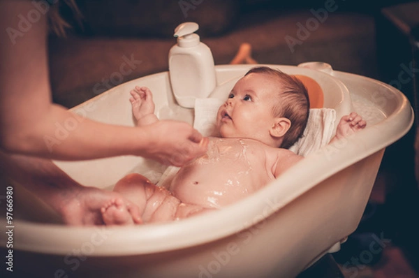 Fototapeta Small baby first bathing
