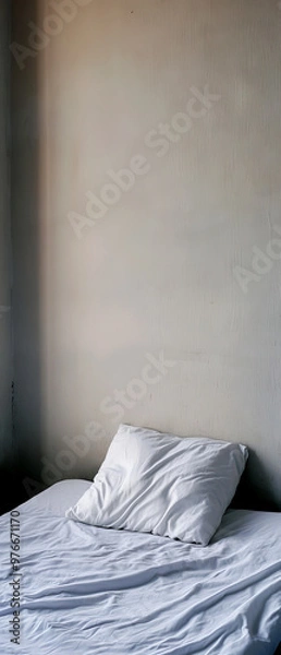 Fototapeta Cozy bed with rumpled sheets and soft pillow against a minimalistic wall, perfect for capturing comfort and relaxation.