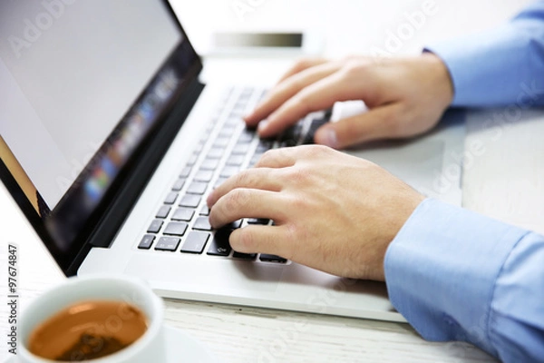 Fototapeta Young businessman using his laptop, close up