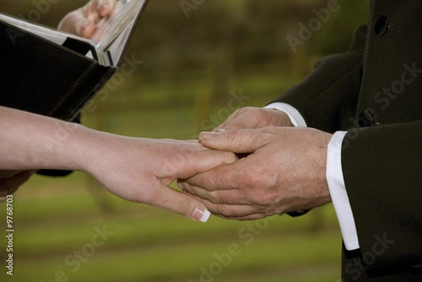 Obraz A couple hold hands during the wedding ceremony