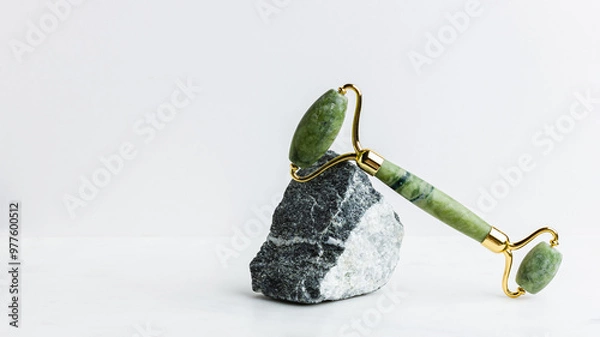 Obraz Green jade roller massager for face on white marble.