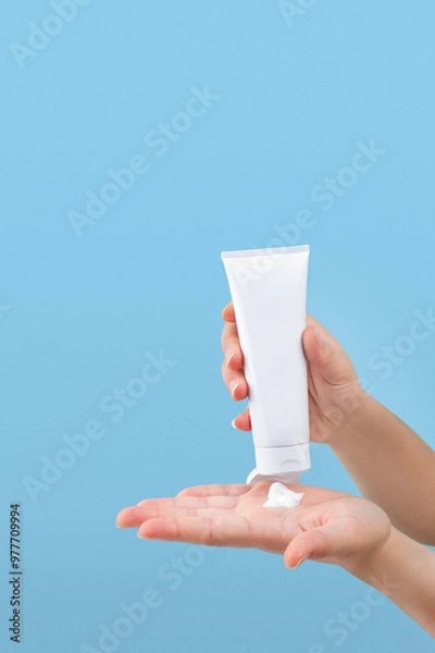 Fototapeta Hand pouring lotion or cream on hand, isolated background 