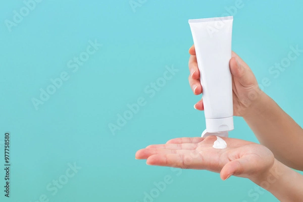 Fototapeta Hand pouring lotion or cream on hand, isolated background 