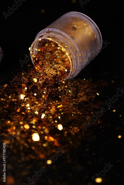 Obraz transparent jar with golden shiny shiny glitter on a black background