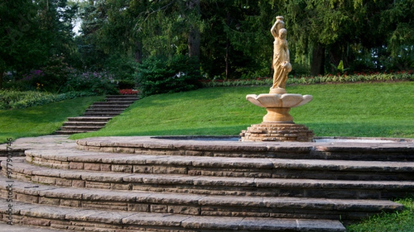 Fototapeta View of the public park with a sculpture and a fountain