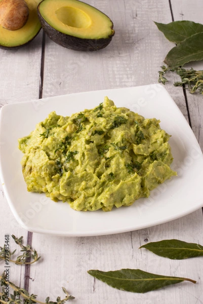 Obraz guacamole sauce with some avocados in the background and some spices