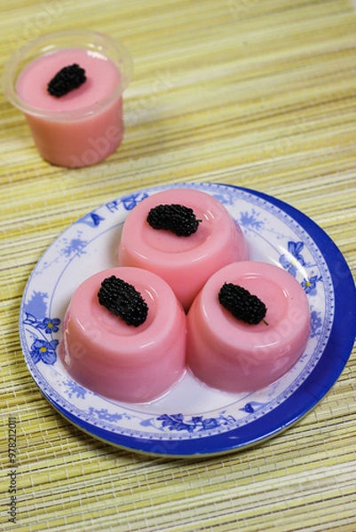 Obraz Pink pudding dessert, each topped with mulberries. The gelatin dessert is smooth and shiny, with a slightly translucent appearance