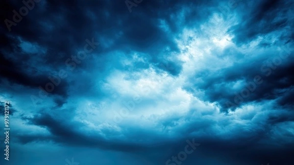 Fototapeta Dramatic dark clouds with shades of blue, creating a moody atmosphere ideal for backgrounds, artwork, and thematic projects.