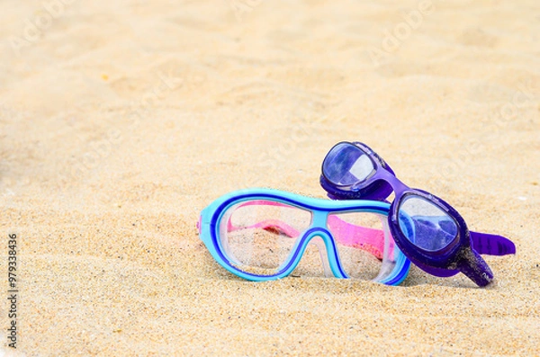 Fototapeta Two pairs of glasses for swimming on a sand background