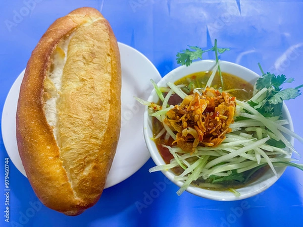 Fototapeta Dalat style pork meatball Banh Mi with dipping sauce including meatballs, shredded spinach and topped with stir-fried chili and fried onions