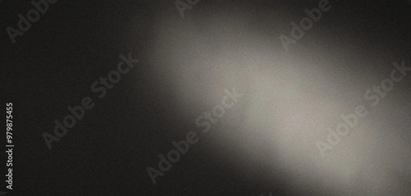 Fototapeta Diagonal beam of light illuminates a grainy dark grey background
