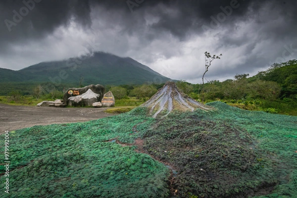 Fototapeta Model of Arenal volcano next to the reals Arenal volcano hiding in the clouds