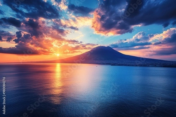 Fototapeta Stunning view of Mount Vesuvius from Naples featuring a blue sea impressive mountains and a captivating cloudy sunset