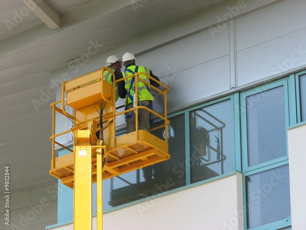 Fototapeta Two contruction workers working on new building