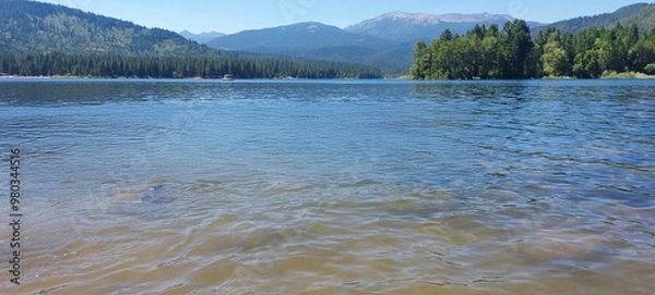 Obraz Shasta lake with a distant forest and mountain range under a clear sky, showcasing peaceful nature at its finest.