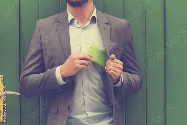 Obraz Young handsome man using smartphone.