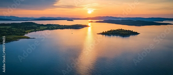 Fototapeta Aerial drone shot of a serene lake coast at sunset with islands and a clear view ahead ideal for use as a copy space image