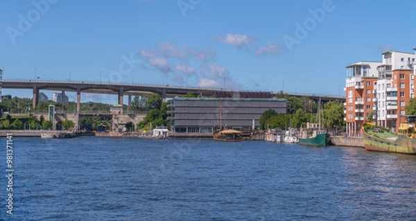 Fototapeta The sluice Hammarbyslussen and the bridges at Skanstull piers with boats in the bay Hammarbysjö, apartment houses, a sunny summer day in Stockholm