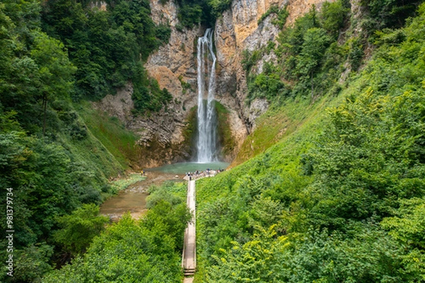 Fototapeta A beautiful waterfall with a wooden path to it surrounded by greenery - Bliha waterfall near Sanski Most in Bosnia and Herzegovina