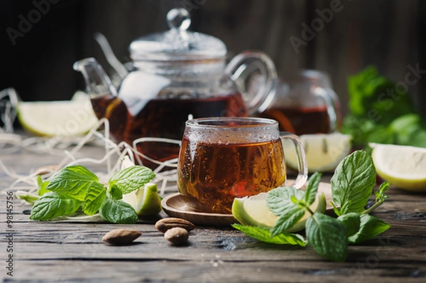 Obraz Hot black tea with lemon and mint on the wooden table