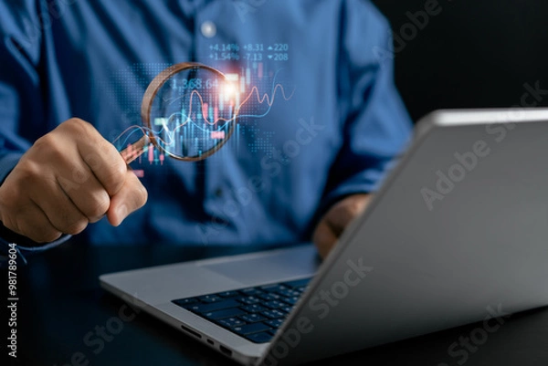 Fototapeta Businessman use magnifier glass find stock in stock markets, uptrends, growth economics, business strategy development, and opportunities for investment, take profit from funds, Financial Analyst.