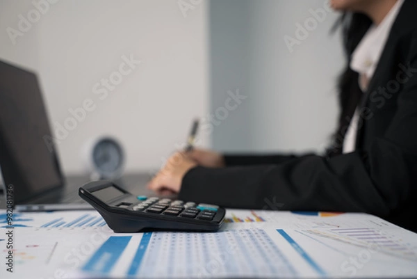 Obraz Doing taxes. Planning budget and calculating expenses while checking her bills with calculator. Managing taxes and financial bills.