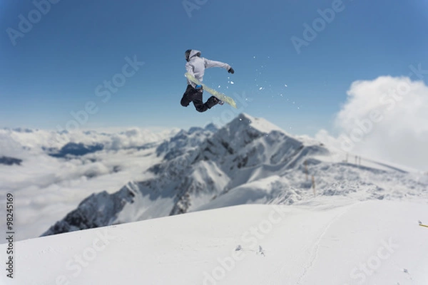 Fototapeta Flying snowboarder on mountains. Extreme sport.