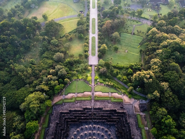 Fototapeta Borobudur Temple - Largest Buddhist Stupa in the world, Aerial drone view from behind showing avenue that leads to temple stairs.