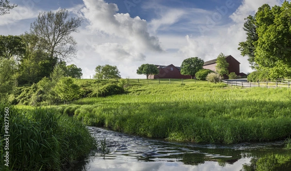 Obraz Red Barns on a Green Hilltop with a Stream Flowing Below