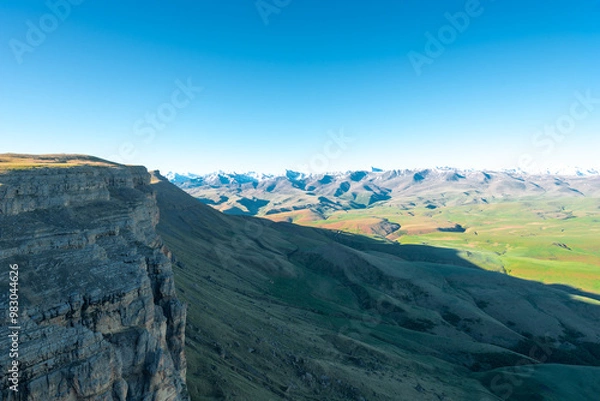 Fototapeta A picturesque view of a rocky cliff against the background of the North Caucasian ridge in the Elbrus region