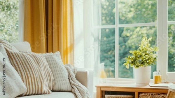 Obraz A beige-striped linen pillow rests on a minimalist sofa, accompanied by a soft white and blue checkered blanket, creating a warm and inviting bohemian atmosphere