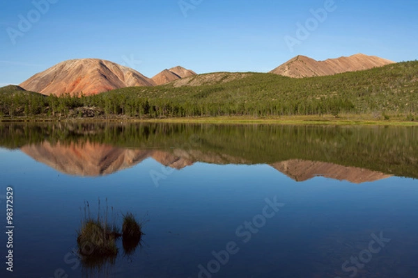 Fototapeta Red Mountain and its reflection in the lake. Oimyakon Highlands. Yakutia. Russia.