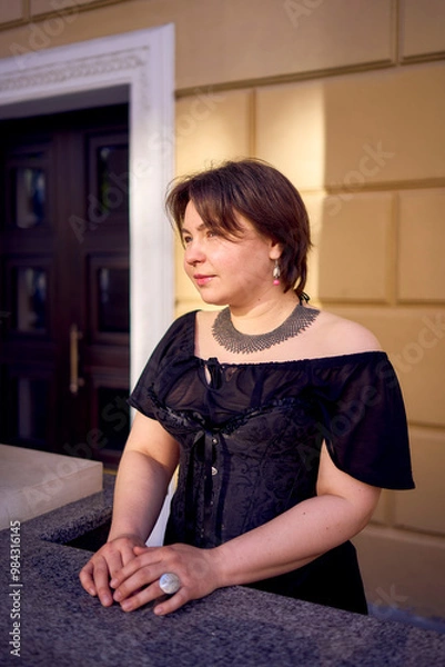 Fototapeta a medium-sized woman in a black corset near a theater with antique columns