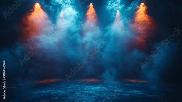 Fototapeta A dark, moody scene with blue and orange spotlights shining through smoke.
