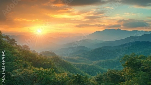 Fototapeta Stunning view of a sunrise over mountains, casting golden light on lush green valleys and creating a tranquil atmosphere.