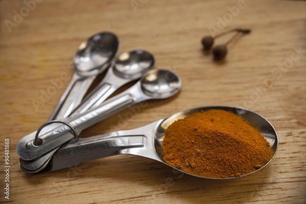 Obraz Four measuring spoons with Tumeric spice
