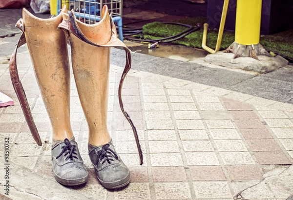 Obraz Old prosthetic legs set on a cement floor. Outdoor view