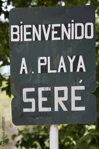 Fototapeta Rusted welcome to beach of Seré sign written in Spanish