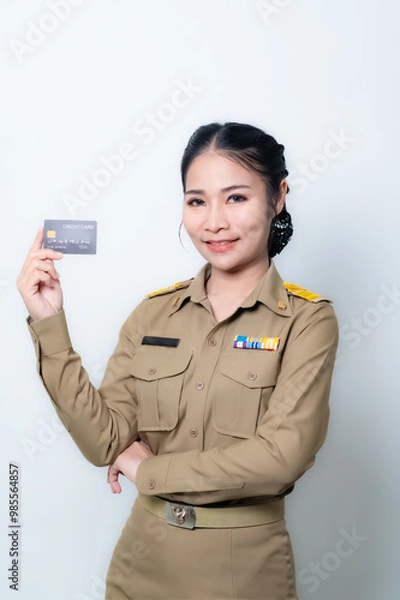 Fototapeta Beautiful Asian female teache pointing to empty copy space isolated on green background.