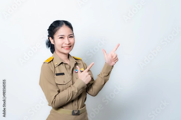 Fototapeta Female Thai government officer in khaki uniforms smiling. Beautiful woman doing winner gesture with arms raised isolated over white background. Concept