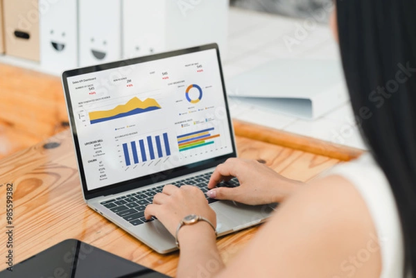 Obraz Businesswoman or an accountant team are analyzing data charts, graphs, and a dashboard on a laptop screen in order to prepare a statistical report and discuss financial data in an office.