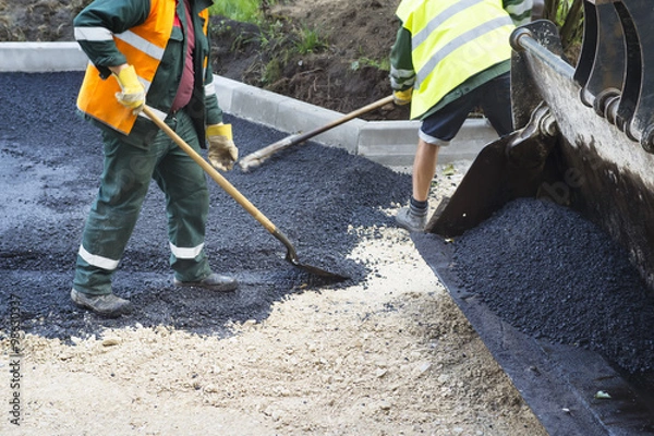Fototapeta Workers making asphalt with shovels at road construction